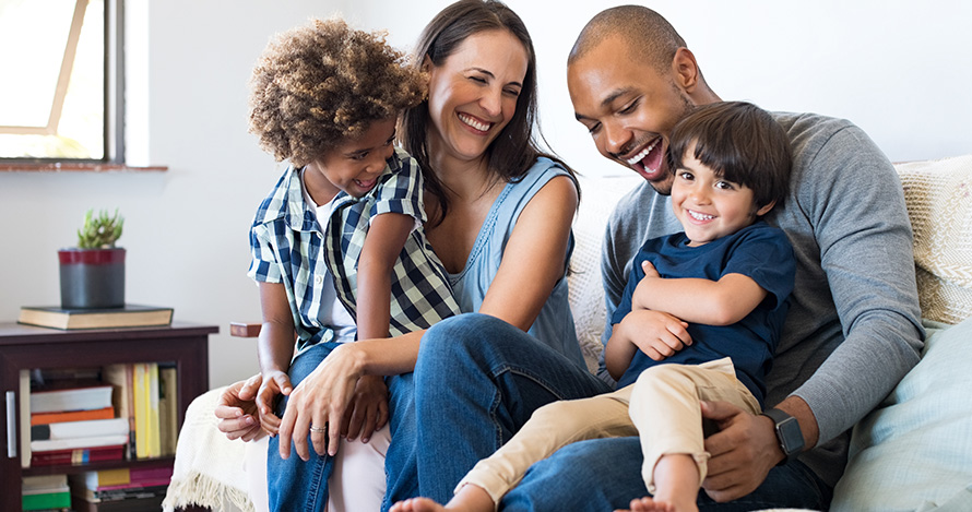  Una familia de raza mixta con hijos adoptados se divierte en casa.