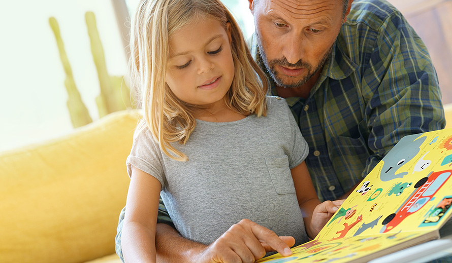 Father and daughter reading together at home.