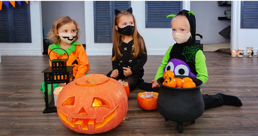Young girls celebrate Halloween in a safe way inside the home during Halloween. 
