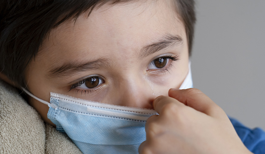 A Hispanic boy looks despondent during the coronavirus pandemic. 