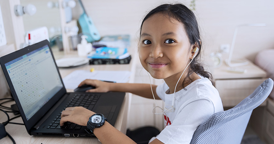 Una niña disfruta del aprendizaje en línea desde casa.