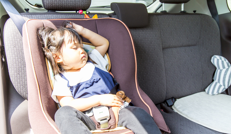 Sun shines on little girl in car seat. 