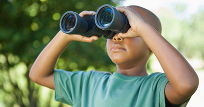 Little boy looking through binoculars.