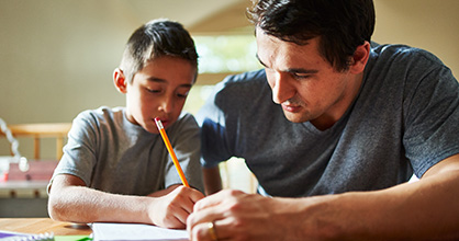 A father tutors his son. 