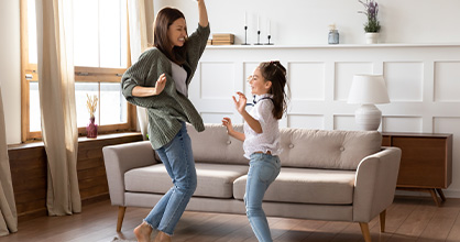 A mother and daughter dance inside to keep active.
